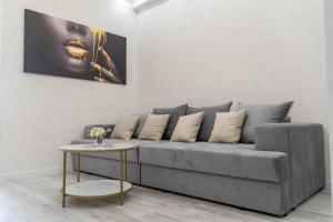 a living room with a gray couch and a table at RentWill apartments Gold in Chişinău