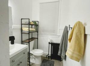 a white bathroom with a toilet and a sink at Lovely 2BR w Office space - KING BED & ALEXA in Pittsburgh