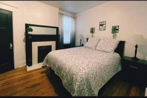 a bedroom with a large bed and a fireplace at Lovely 2BR w Office space - KING BED & ALEXA in Pittsburgh