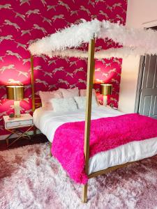 a bedroom with a bed with a pink wall at Dolly's Delight - Boutique Bliss Mins From Broadway in Nashville