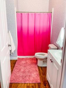 a pink shower curtain in a bathroom with a toilet at Dolly's Delight - Boutique Bliss Mins From Broadway in Nashville