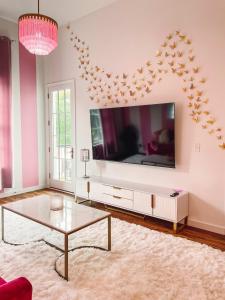 a living room with a large television and a coffee table at Dolly's Delight - Boutique Bliss Mins From Broadway in Nashville