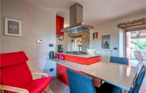 a kitchen with red and blue chairs and a counter at 1 Bedroom Gorgeous Apartment In Bossolasco in Bossolasco