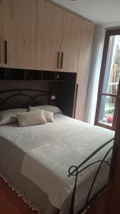 a bedroom with a white bed with a window at Mary's Home in Madonna della Costa +10 photos