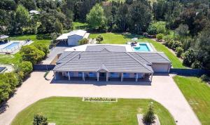 uma vista aérea de uma grande casa com piscina em Coast and Country Estate - 15m Heated Pool and Minutes to Beach em One Mile