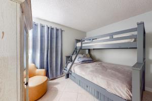 a bedroom with a bunk bed and a chair at Plantation East IV in Gulf Shores