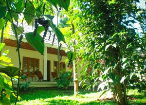 a small house in the middle of a yard at Green Court Cottages in Thekkady