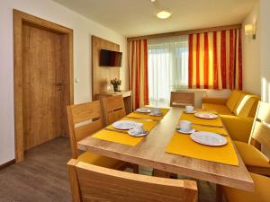 a room with a dining table and a living room at Appartement Gästehaus Bergkristall in Sölden