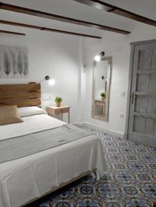 - une chambre avec un grand lit et un miroir dans l'établissement El MANANTIAL, à Zahara de la Sierra