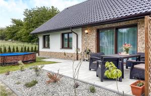 a patio with a table and chairs in front of a house at 3 Bedroom Nice Home In Wiselka in Wisełka