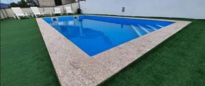 a swimming pool with blue water and grass at Alojamento Silva in Castelo de Paiva +14 photos
