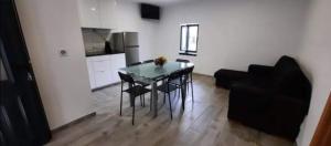 a living room with a table and a black couch at Alojamento Silva in Castelo de Paiva