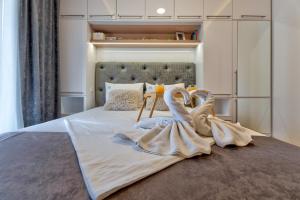 een slaapkamer met 2 zwanenhanddoeken op een bed bij Apartman Melody Lux & Spa in Zlatibor