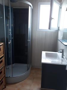 La salle de bains est pourvue d'une douche et d'un lavabo. dans l'établissement Maison entre Terre et Mer avec Jacuzzi, à Sauzon