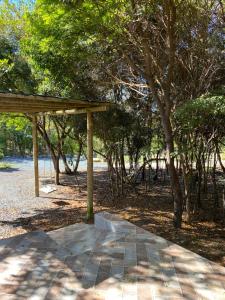 un pavillon en bois dans un parc arboré dans l'établissement Chalé Verde - Vale do Capão, à Vale do Capão