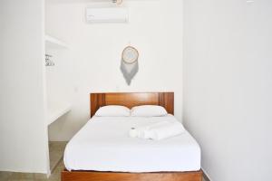 a bedroom with a bed with a clock on the wall at Xula Bacalar in Bacalar