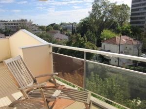 een balkon met een stoel en uitzicht op de stad bij City Break Picquecailloux in Bordeaux