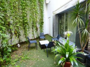 een patio met stoelen en een tafel voor een gebouw bij Apartamento Un Jardin en la Alfalfa - Kainga Homes in Sevilla