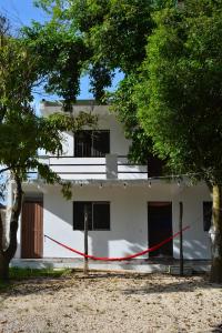 a white building with a red rope in front of it at Xula Bacalar in Bacalar