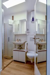 La salle de bains blanche est pourvue de 2 lavabos et de toilettes. dans l'établissement Lütte Auszeit Scharbeutz, à Scharbeutz