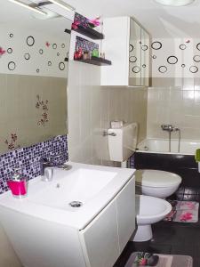 uma casa de banho com um lavatório branco e um WC. em Sweet Home Appartamento 4 posti letto 10 min dal mare em Badalucco
