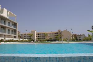 a large swimming pool with buildings in the background at Apartamento en primera línea (Mejor clima de Europa). in Torrox Costa