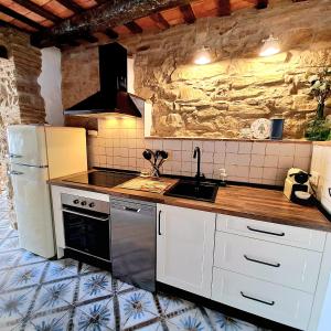 a kitchen with a stove and a sink and a refrigerator at Casa Romántica con Sauna privada Eternal Rural in Jimena de la Frontera