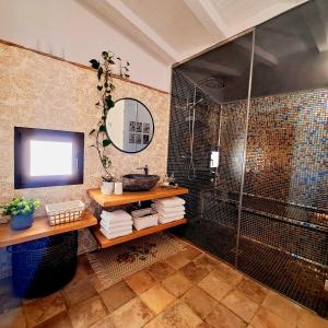 a bathroom with a shower and a sink and a mirror at Casa Romántica con Sauna privada Eternal Rural in Jimena de la Frontera
