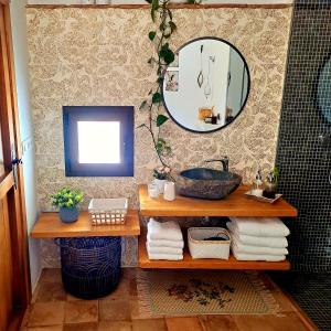 a bathroom with a sink and a mirror on a wall at Casa Romántica con Sauna privada Eternal Rural in Jimena de la Frontera