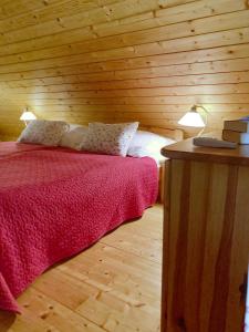 a bedroom with a bed and a wooden wall at Zsóka Fogadója in Szentantalfa