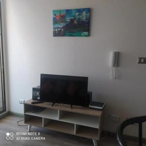 a flat screen tv sitting on a stand in a living room at CONDOMINIO TERRASOL 1 in Quilpué