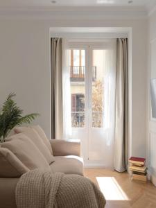 un soggiorno con divano e finestra di DELUXE APARTMENT NEAR GRAN VIA a Madrid