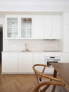 uma cozinha com armários brancos e uma mesa de madeira em DELUXE APARTMENT NEAR GRAN VIA em Madri