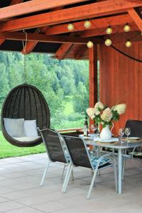 un patio con mesa, sillas y un columpio en Hortenzie en Kašperské Hory