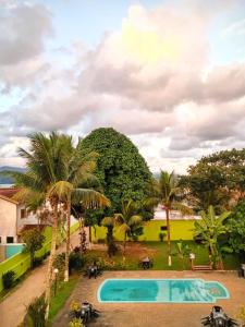 a view of a swimming pool with palm trees at Pousada Flor de Jambo in Ubatuba