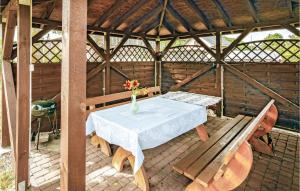 a table and bench in a wooden gazebo at 2 Bedroom Stunning Home In Mielno in Mielno