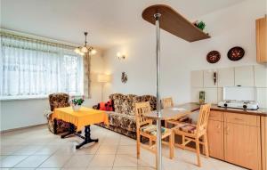 eine Küche und ein Wohnzimmer mit einer Couch und einem Tisch in der Unterkunft Holiday Home Mielno Akacjowa in Mielno