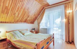 a bedroom with a bed and a large window at 2 Bedroom Stunning Home In Mielno in Mielno