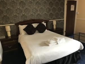 a bedroom with a bed with towels on it at The Old Coach House in Buckie