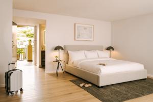 1 dormitorio blanco con 1 cama y 1 maleta en Sonder La Ensenada, en Laguna Beach