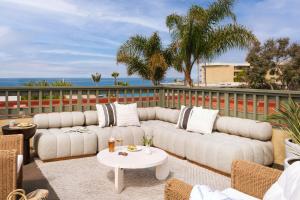 un patio con un sofá blanco y una mesa en Sonder La Ensenada, en Laguna Beach