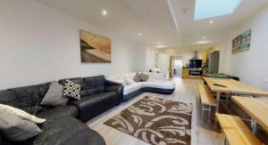 uma sala de estar com um sofá e uma mesa em Myrtle Villa Rooms em Weymouth