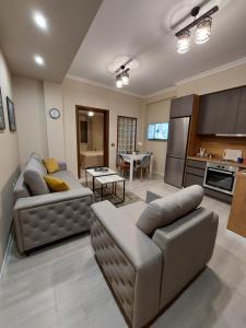 uma sala de estar com dois sofás e uma cozinha em Vila TAFA Apartments em Tirana