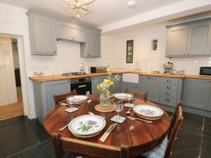 une cuisine avec une table en bois et des plaques de cuisson. dans l'établissement Wenallt, à Porthmadog