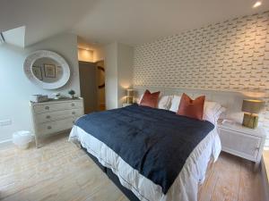 a bedroom with a large bed and a mirror at Linhay Cottages in Box