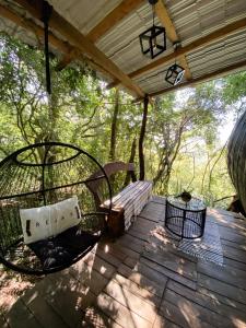 a porch with a swing and a bench on a deck at Salto Suizo Parque Ecologico in Independencia +20 photos