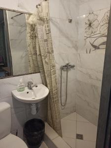 een badkamer met een douche, een wastafel en een toilet bij Готель Жасмин in Ternopilʼ