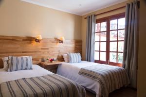 Palmilla的住宿－Hotel Viña Kankura，一间卧室设有两张床和窗户。