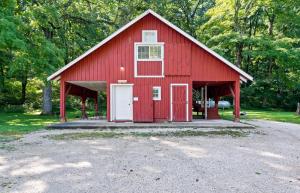 a red barn with a white door in the middle at Wilstem Cabins in French Lick