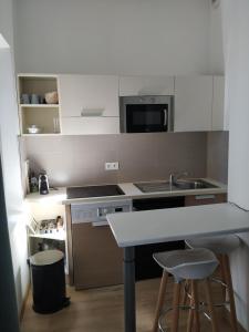 uma pequena cozinha com um balcão e um micro-ondas em STUDIO CANNES A 5 MN A PIED DE LA GARE TOUT CONFORT AVEC BALCON em Cannes